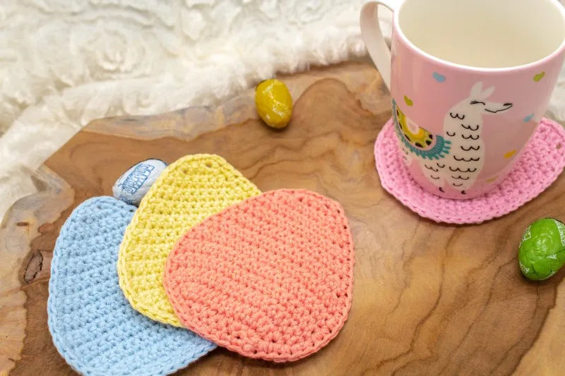 Verschillende gehaakte onderzetters in ei vorm bij elkaar, onderzetters gehaakt met Haakpatroon onderzetter Eggy ontworpen door Cora's Knit Knacks
