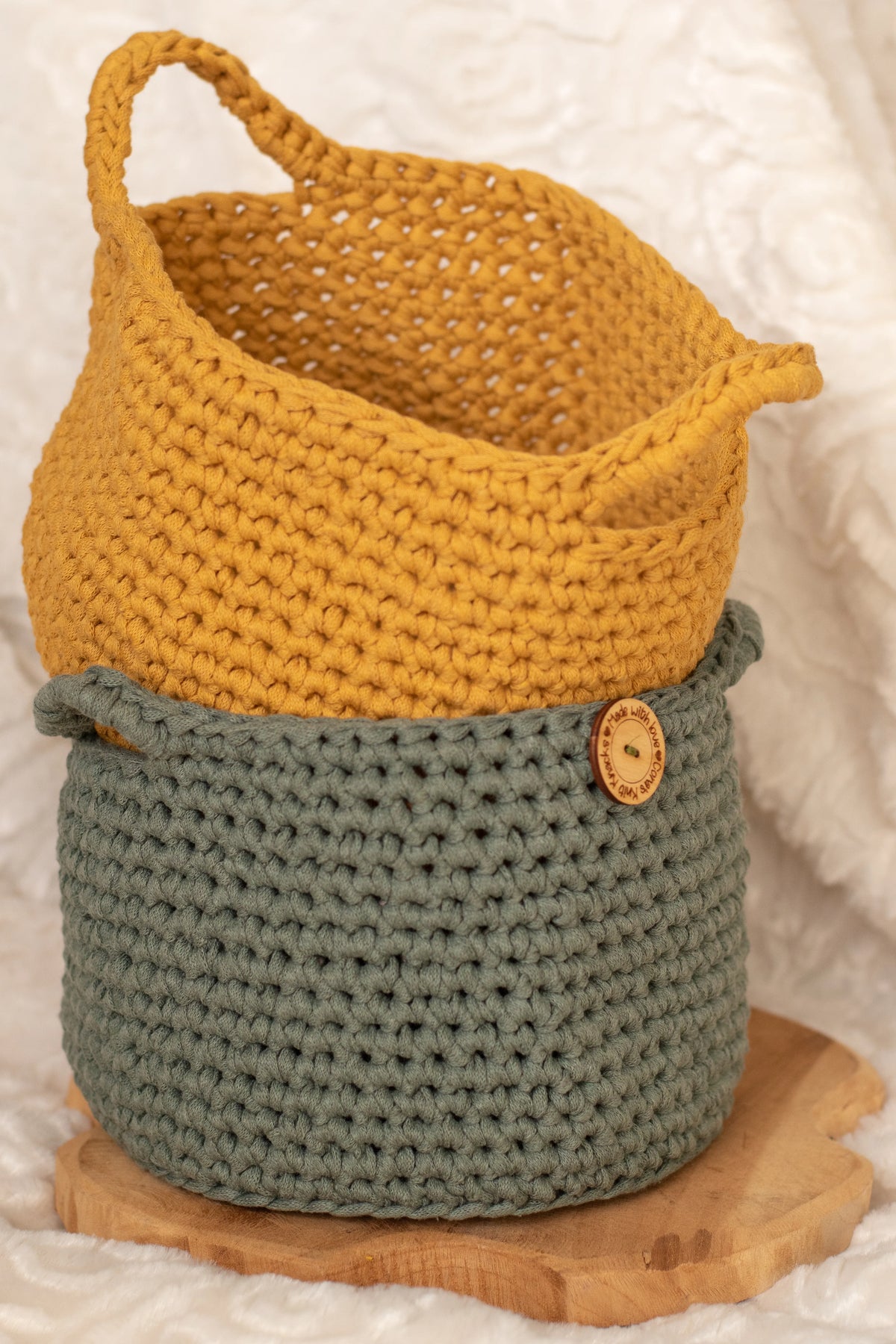 Donkergroene en okergele gehaakte manden in elkaar gestapeld, manden gemaakt met Haakpatroon mand Maartje ontworpen door Cora's Knit Knacks