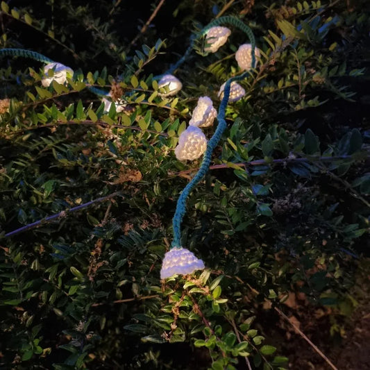 Gehaakt Haakpatroon bloemetjes lichtslinger ontworpen door Cora's Knit Knacks, in het donker met de lichtjes aan