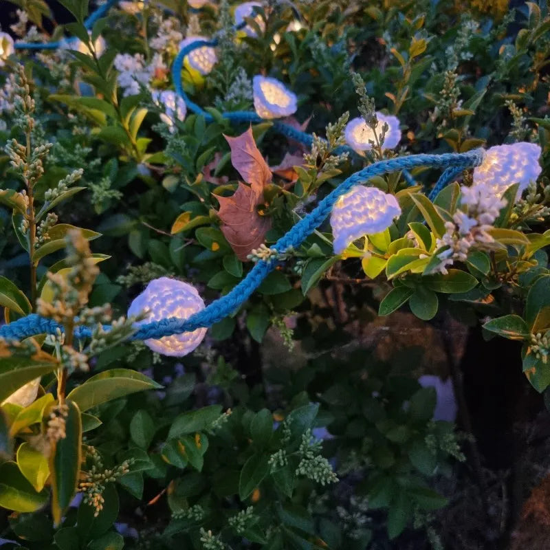 Gehaakt Haakpatroon bloemetjes lichtslinger ontworpen door Cora's Knit Knacks, in een plant, met de lichtjes aan