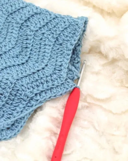 Clover Amour haaknaald aan een haakwerk, op een witte ondergrond