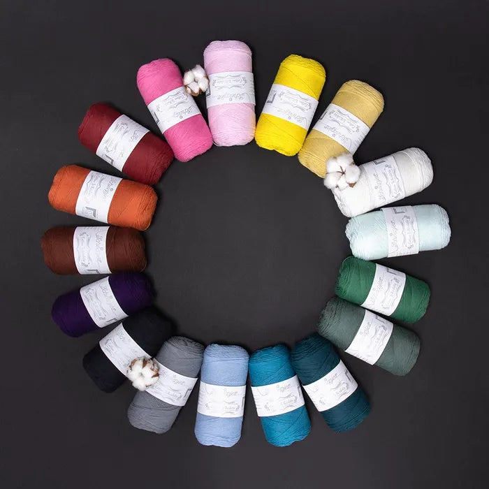 Verschillende kleuren Scheepjes Cotton Whirlette bij elkaar op een zwarte ondergrond
