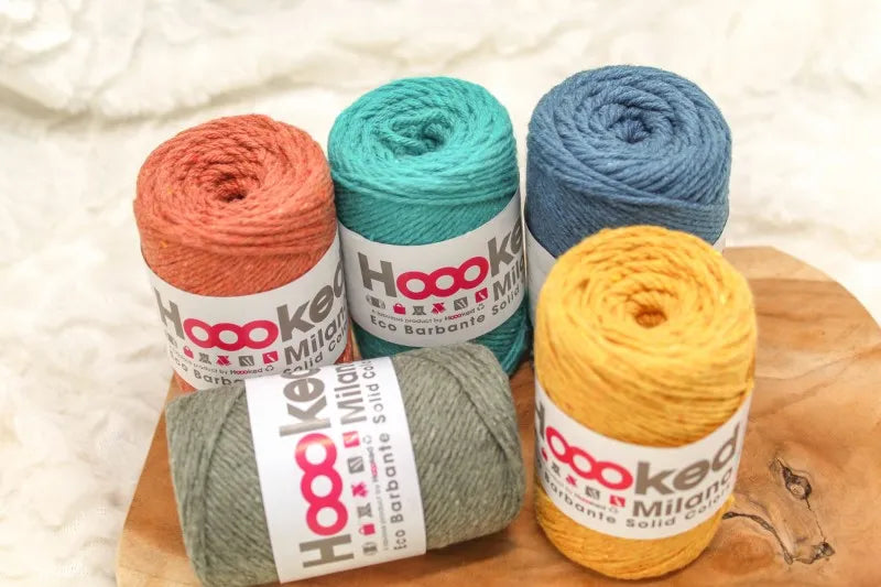 5 bolletjes Hoooked Eco Barbante Milano 100 gram op een houten ondergrond