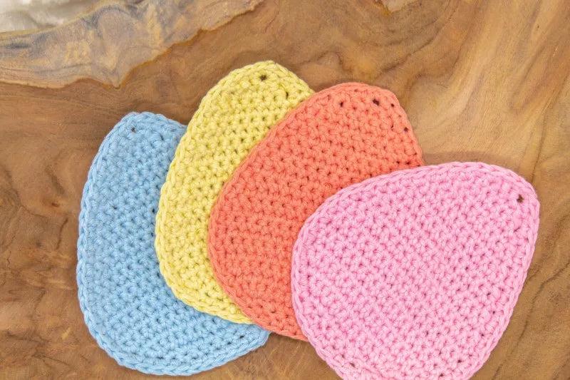 Verschillende gehaakte onderzetters in ei vorm bij elkaar, onderzetters gehaakt met Haakpatroon onderzetter Eggy ontworpen door Cora's Knit Knacks