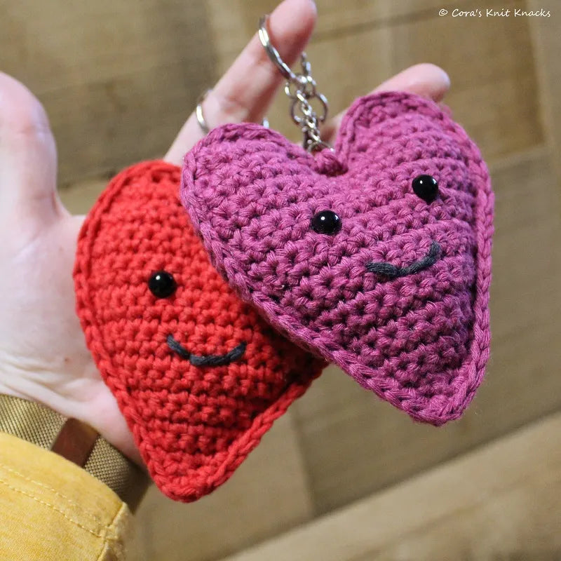 Rode en paarse gehaakte sleutelhangers gemaakt met Haakpatroon Happy Heart sleutelhanger ontworpen door Cora's Knit Knacks