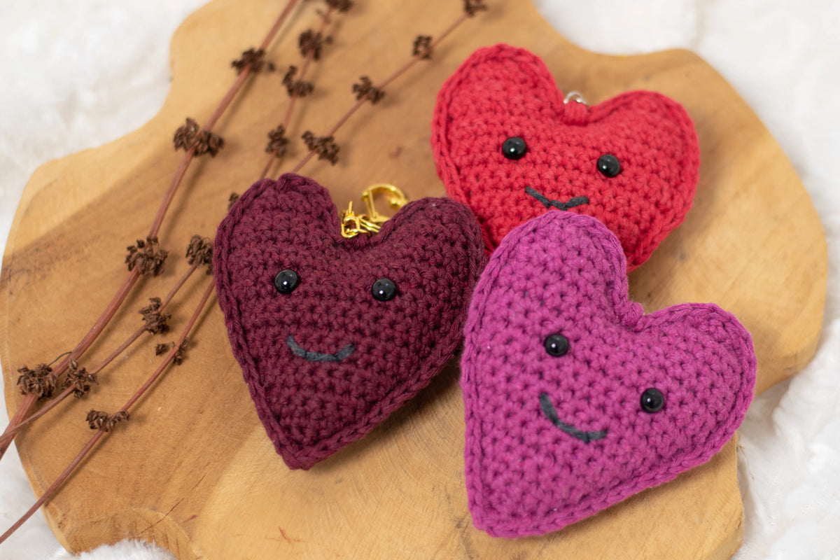 Meerdere gehaakte sleutelhangers gemaakt met Haakpatroon Happy Heart sleutelhanger ontworpen door Cora's Knit Knacks