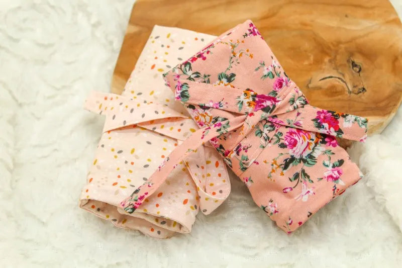 Twee kleine haaknaalden etui's gemaakt door Pukkiez die naast elkaar liggen op een houten ondergrond
