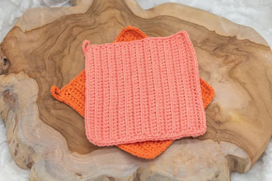 Oranje en licht oranje gehaakte pannenlappen gemaakt met  Haakpatroon pannenlap Ridge ontworpen door Cora's Knit Knacks