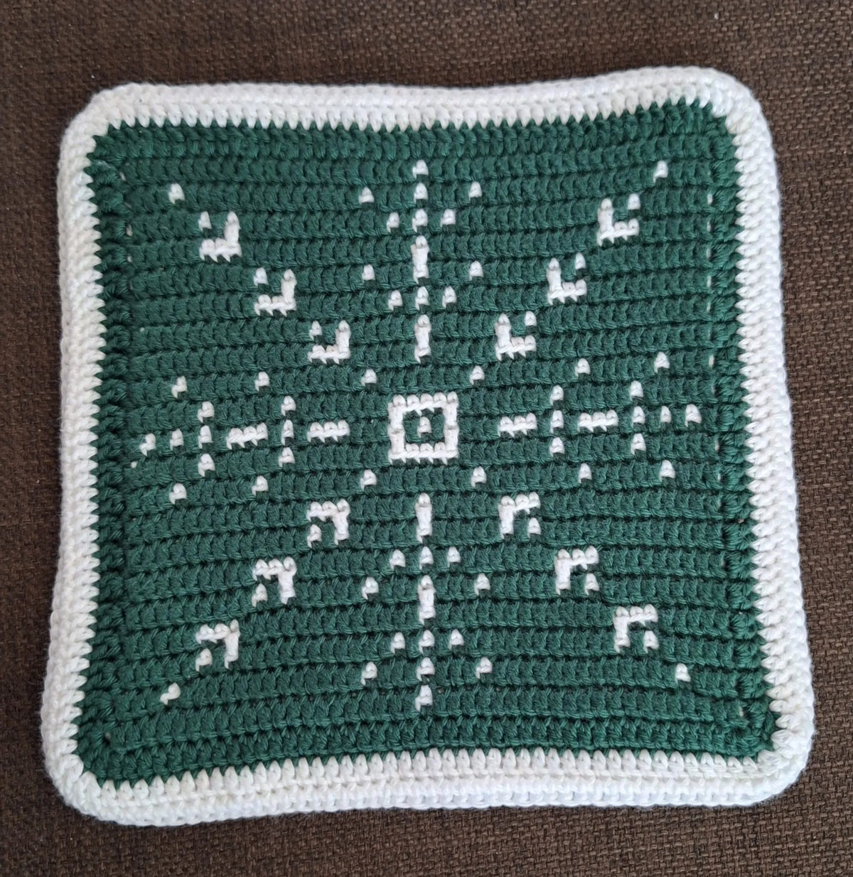 Close up van de groene kant van het gehaakte Haakpatroon panonderzetter Snowflake ontworpen door Haaksels en breisels