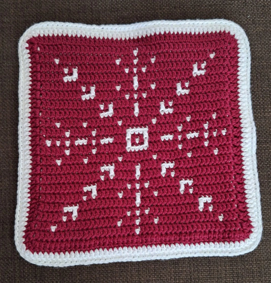Close up van de rode kant van het gehaakte Haakpatroon panonderzetter Snowflake ontworpen door Haaksels en breisels