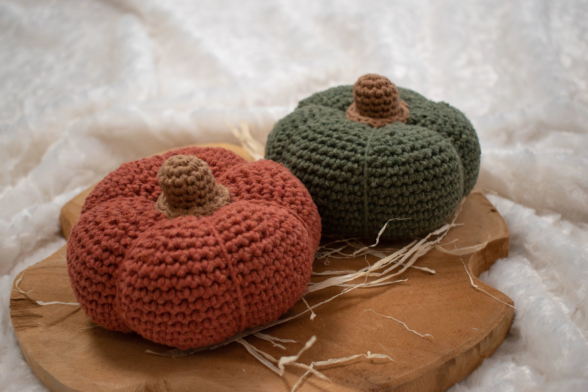 Donkergroene en donkeroranje gehaakte pompoenen gemaakt met Haakpatroon pompoen Zucca ontworpen door Cora's Knit Knacks