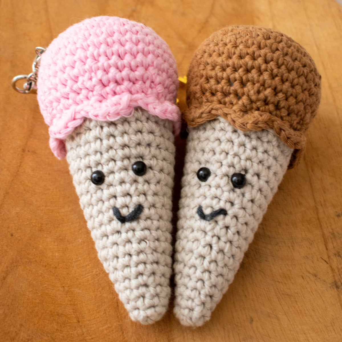 Gehaakt Haakpatroon sleutelhanger ijsje Lia ontworpen door Cora's Knit Knacks, roze en bruin ijsje op een houten ondergrond