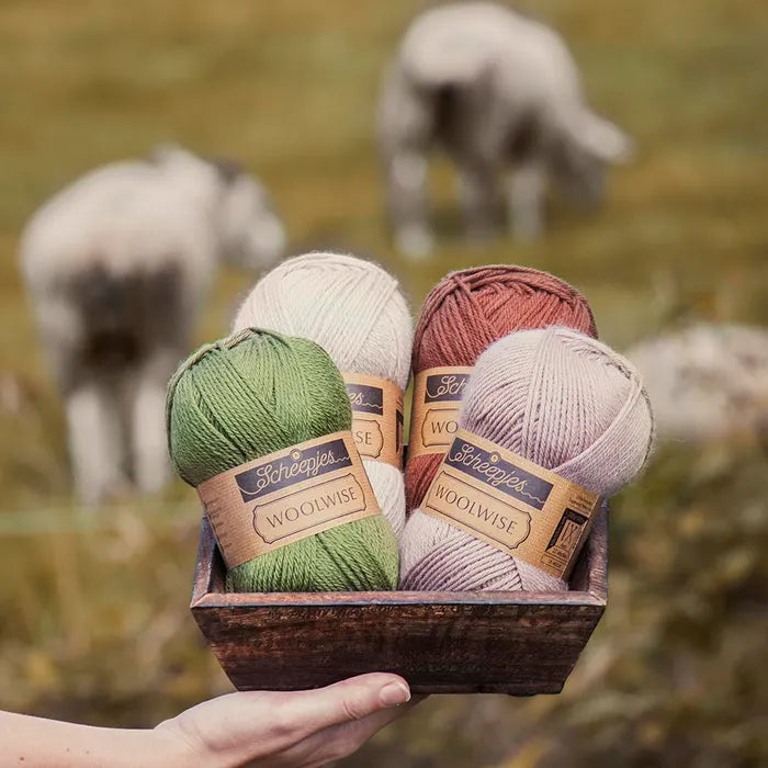 Vier bollen diervriendelijke, gerecyclede wol van Scheepjes bij elkaar: Woolwise in de kleuren gebroken wit, bruin, groen en grijs
