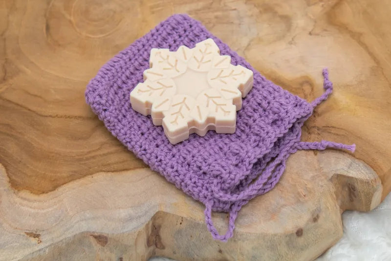 Paars gehaakt zeepzakje met een zeepje erop, zeepzakje gemaakt met Haakpatroon zeepzakje Zippy ontworpen door Cora's Knit Knacks