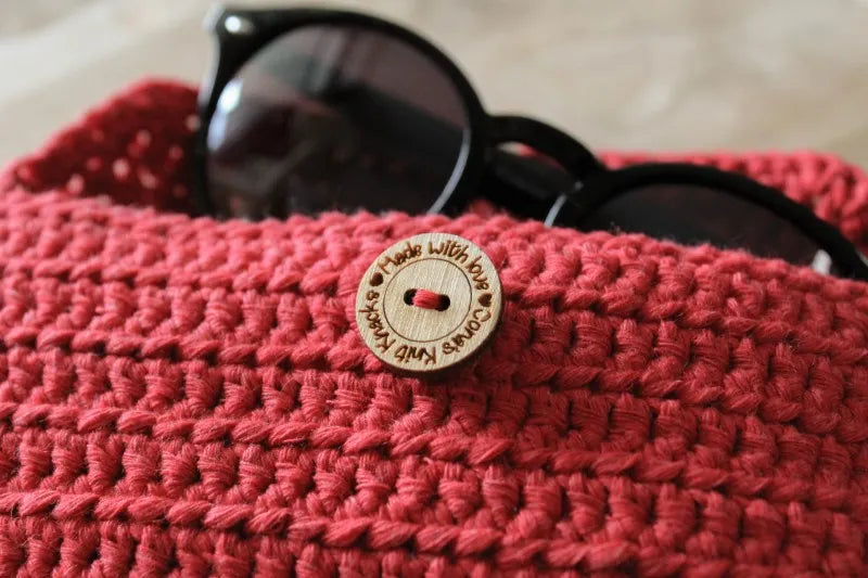 Close up van het gehaakte Haakpatroon zonnebrilhoesje Zelma met een zonnebril erin, patroon ontworpen door Cora's Knit Knacks